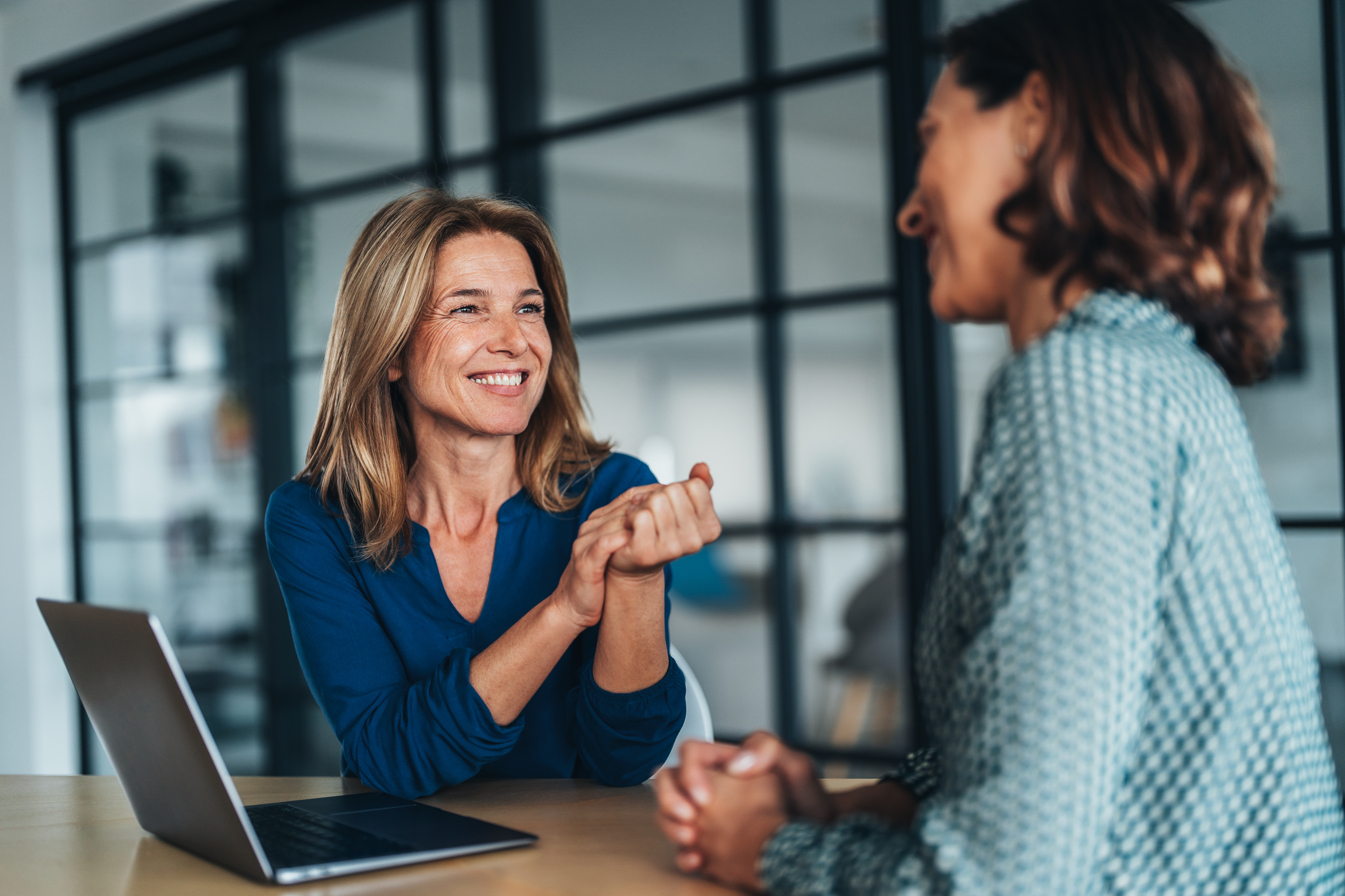 Two Women Smiling And Chatting