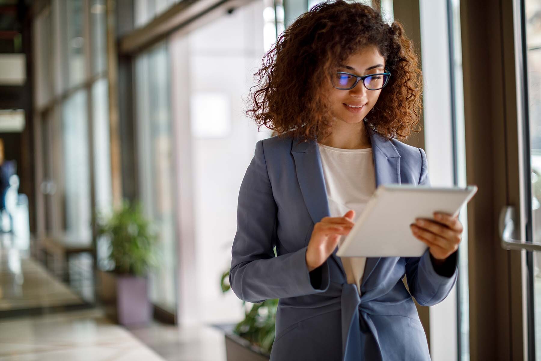 A young woman in a professional environment using her IPad