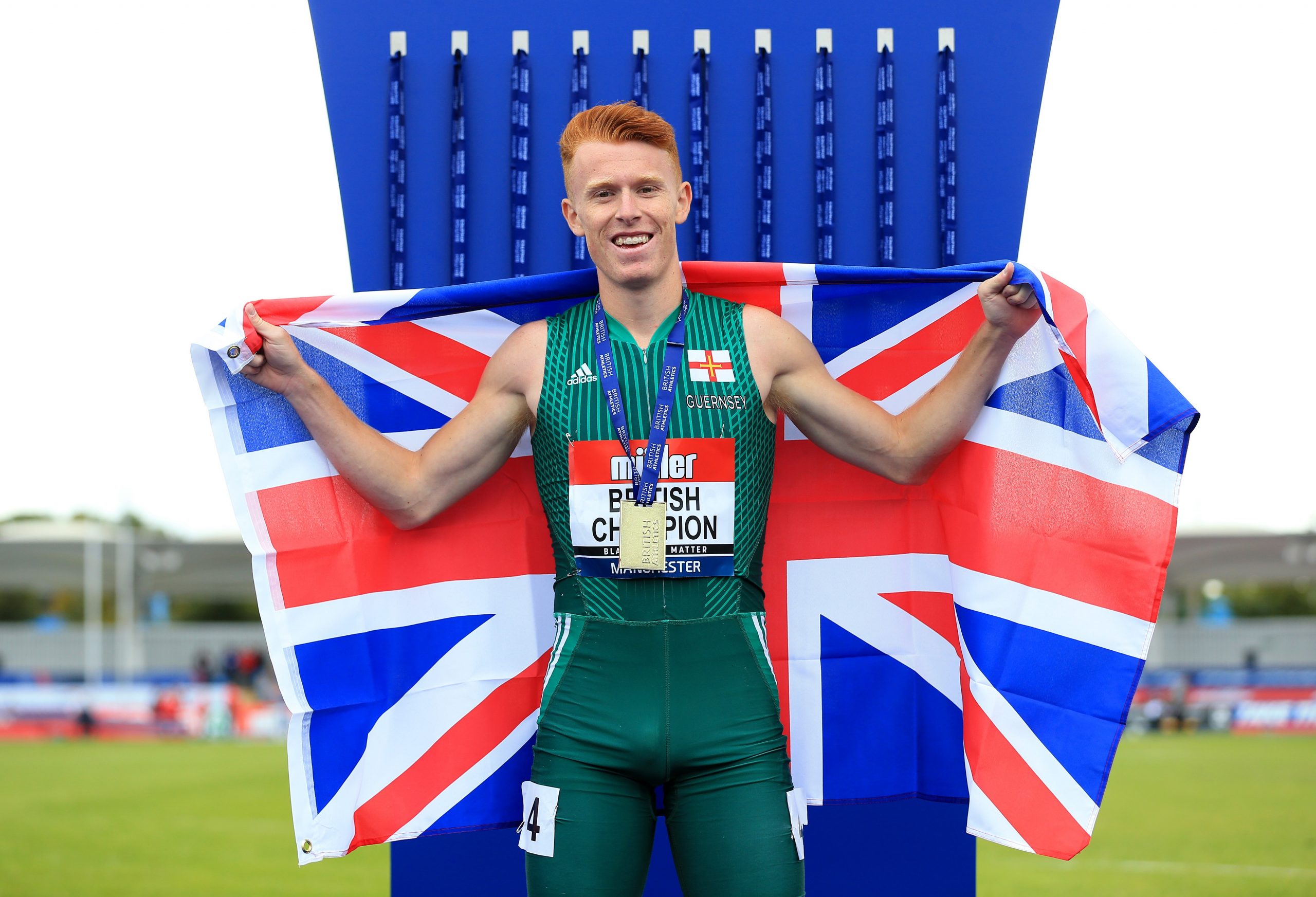 Alastair Chalmers posing at the CommonWealth Games with a GB flag